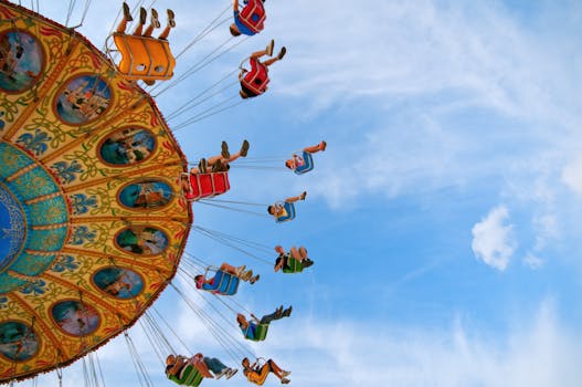 Colorful swing ride at an amusement park with people enjoying a thrilling day under the clear blue sky.