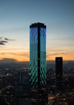 Captivating view of illuminated skyscrapers in Bogota, Colombia at sunset, showcasing modern architecture.